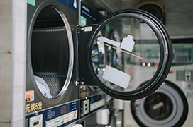 Close up of open dryer door in a laundromat.