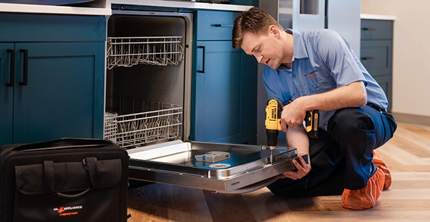 Mr. Appliance service professional reviewing inside of a dishwasher.