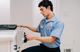 Mr. Appliance service professional turning knob on front of oven.