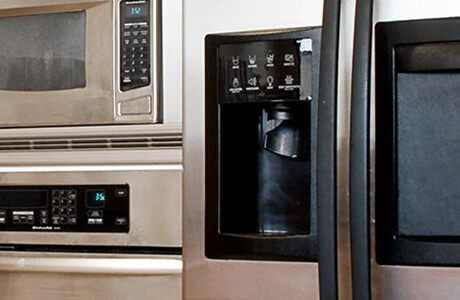 Close-up of various stainless steel kitchen appliances.