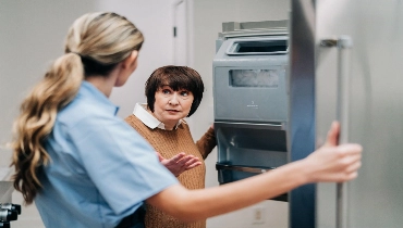 Woman and Mr.Appliance professional speaking in front of open fridge.