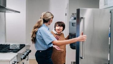 A woman and Mr. Appliance professional discussion their fridge.