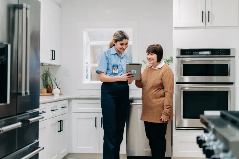 service professional consulting with homeowner about refrigerator repairs.