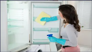 Lady cleaning the fridge